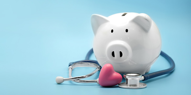 Piggy bank with stethoscope and heart on blue background